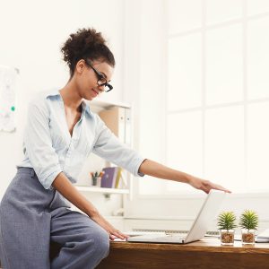 business-woman-opening-laptop-at-office-PU4ZAGW_rtl-min